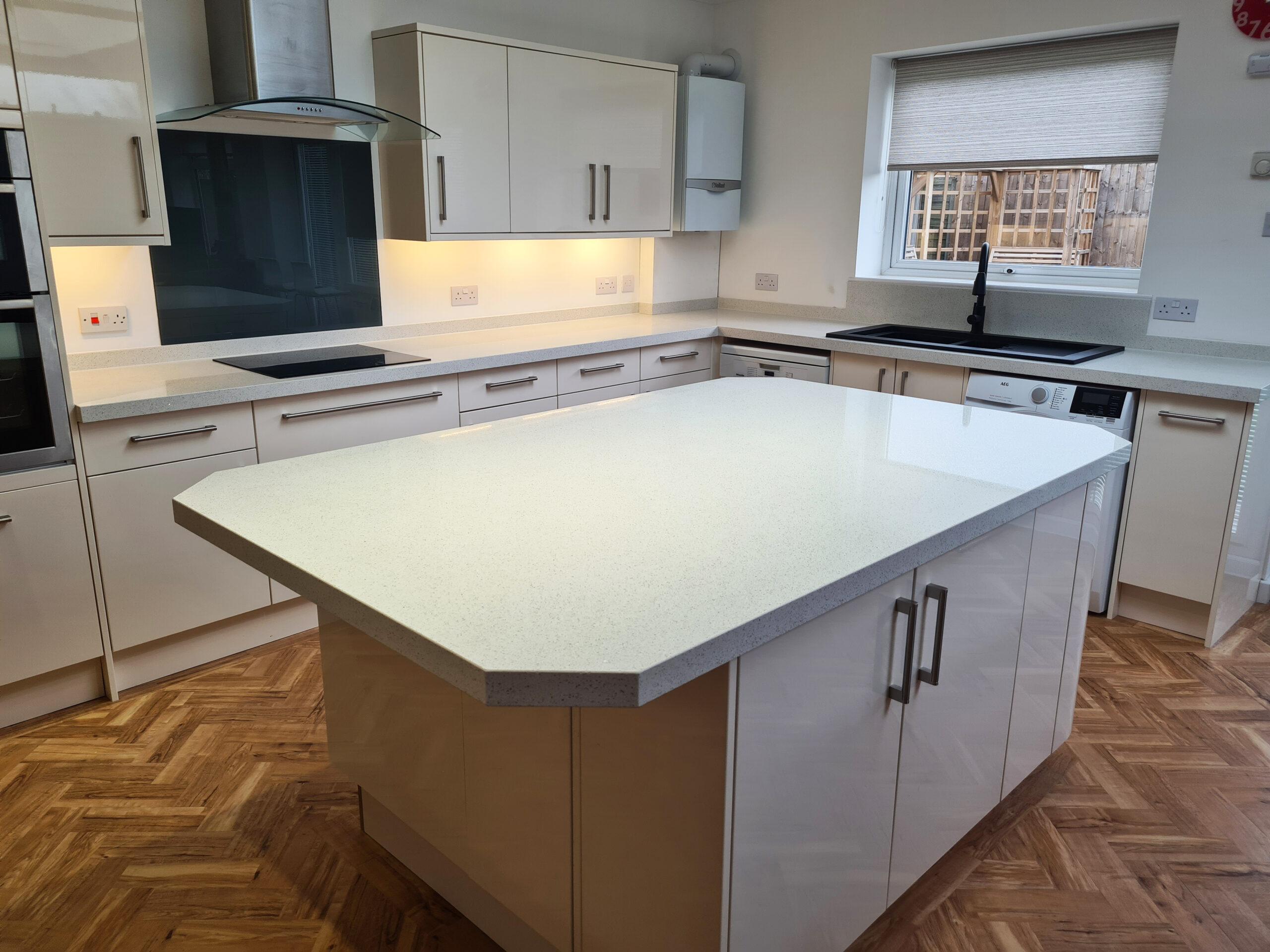 White shaker kitchen with central island and wood-effect flooring