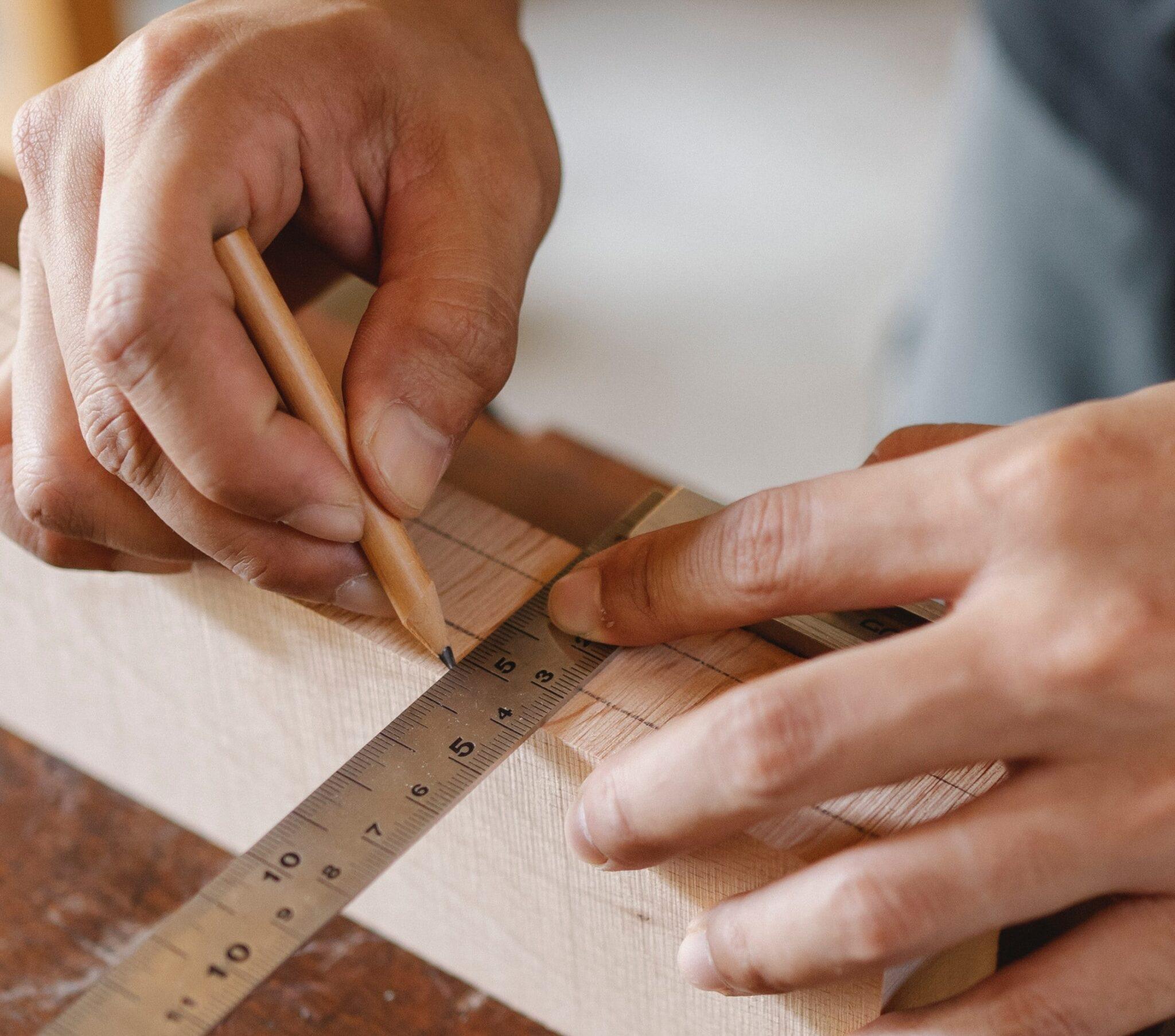 Hands joining kitchen cabinetry with traditional craftsmanship.