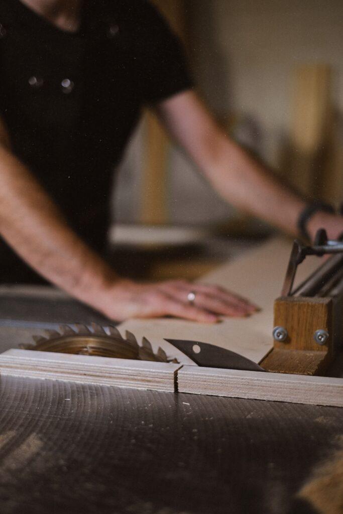 Installer cutting panel on a table saw for kitchen fitting.