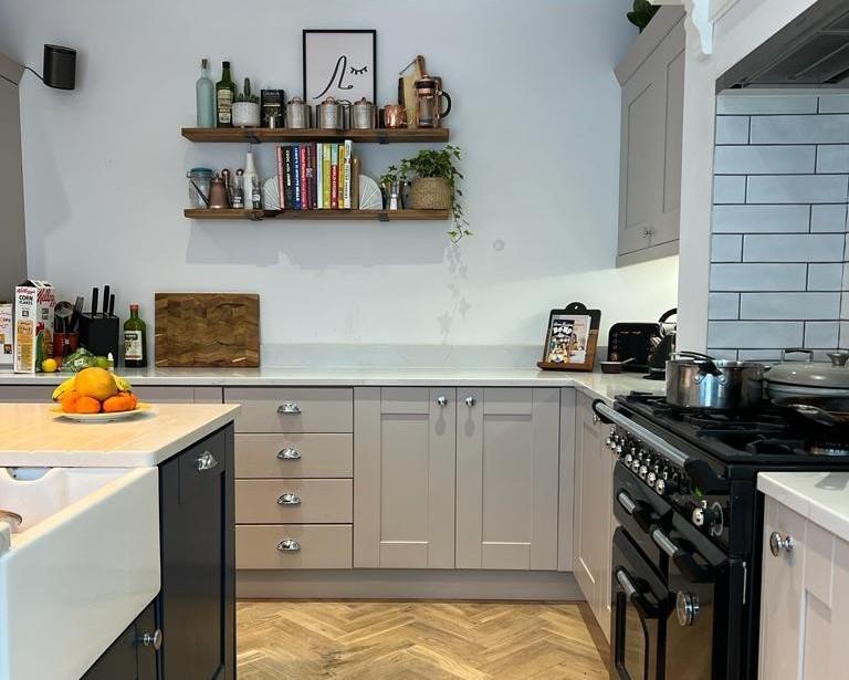 Two-tone kitchen with herringbone flooring and black range cooker