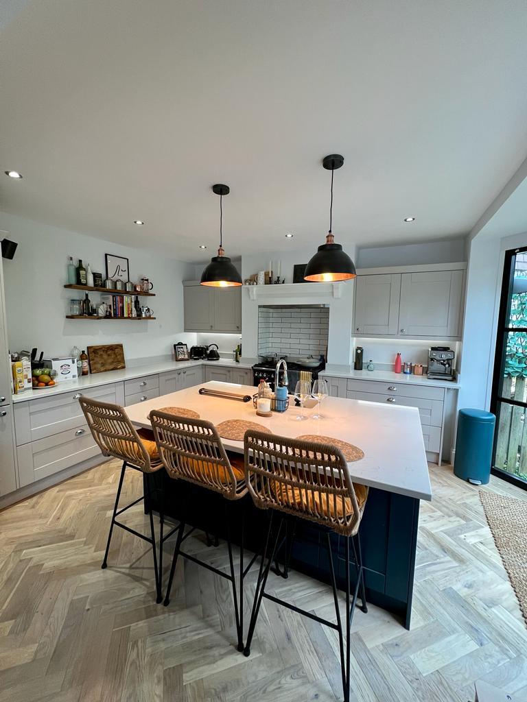 Open-plan kitchen diner with wooden table and modern pendant lights
